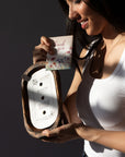 Woman holding a Bulaklak Wooden Bowl Candle and a 'thank you' card against a dark background