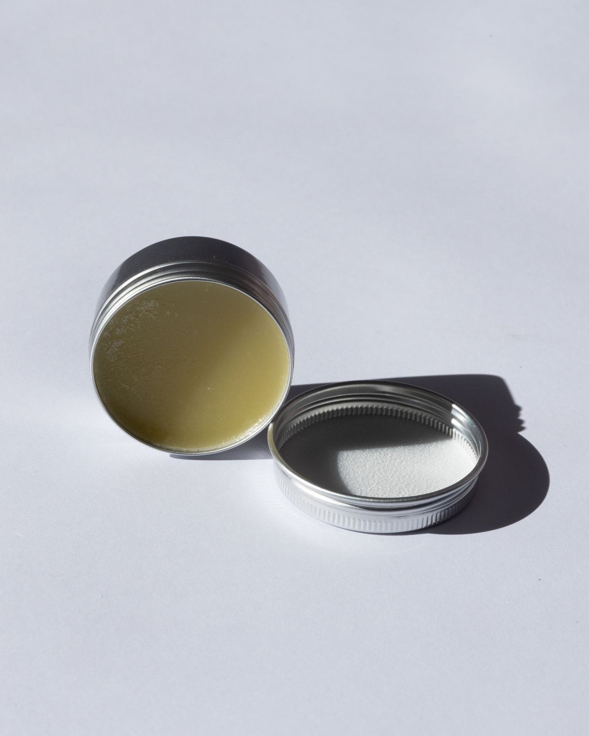 Arnica Salve lid open on a light gray background