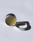 Arnica Salve lid open on a light gray background