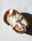 Bulaklak Wooden Bowl Candle in a wooden mold with decorative flowers and a ribbon on a light background