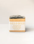 Bar of charcoal soap with 'Ives & Bees' packaging on a white background