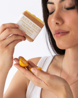 Woman holding a Calamansi Soap labeled 'Ives & Bees' with a close-up of the soap and her hand.
