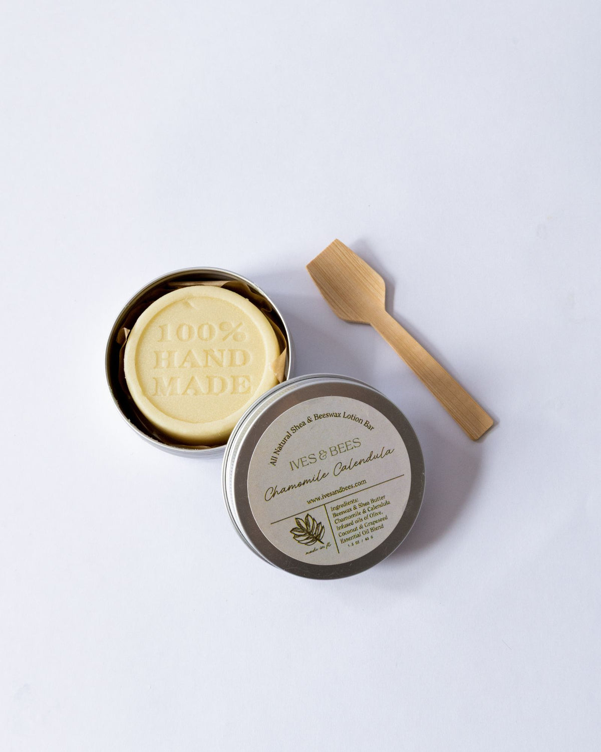 Chamomile and Calendula Lotion Bar in a box with a wooden spoon on a white background