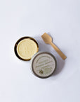 Chamomile and Calendula Lotion Bar in a box with a wooden spoon on a white background