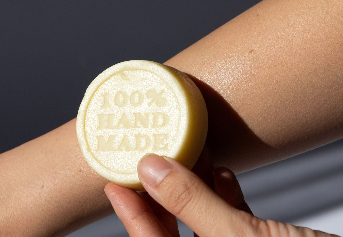 Chamomile and Calendula Lotion Bar with '100% Hand Made' text held against skin