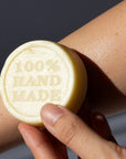 Chamomile and Calendula Lotion Bar with '100% Hand Made' text held against skin