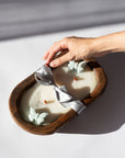 Hand interacting with a Diwata Wooden Bowl Candle