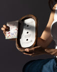 Person holding a Diwata Wooden Bowl Candle with a card featuring 'thank you' text on a dark background