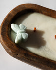 Butterfly-shaped soap in a wooden bowl with a candle