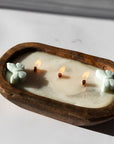 Diwata Wooden Bowl Candle with butterfly-shaped wicks in a wooden holder on a white surface