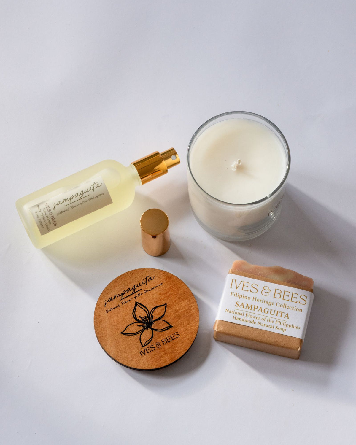 Handmade Filipino Heritage Sampaguita Gift skincare products including a candle, bottle, wooden lid, and soap on a white background