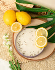 Candle with lemon slices and leaves on a woven surface