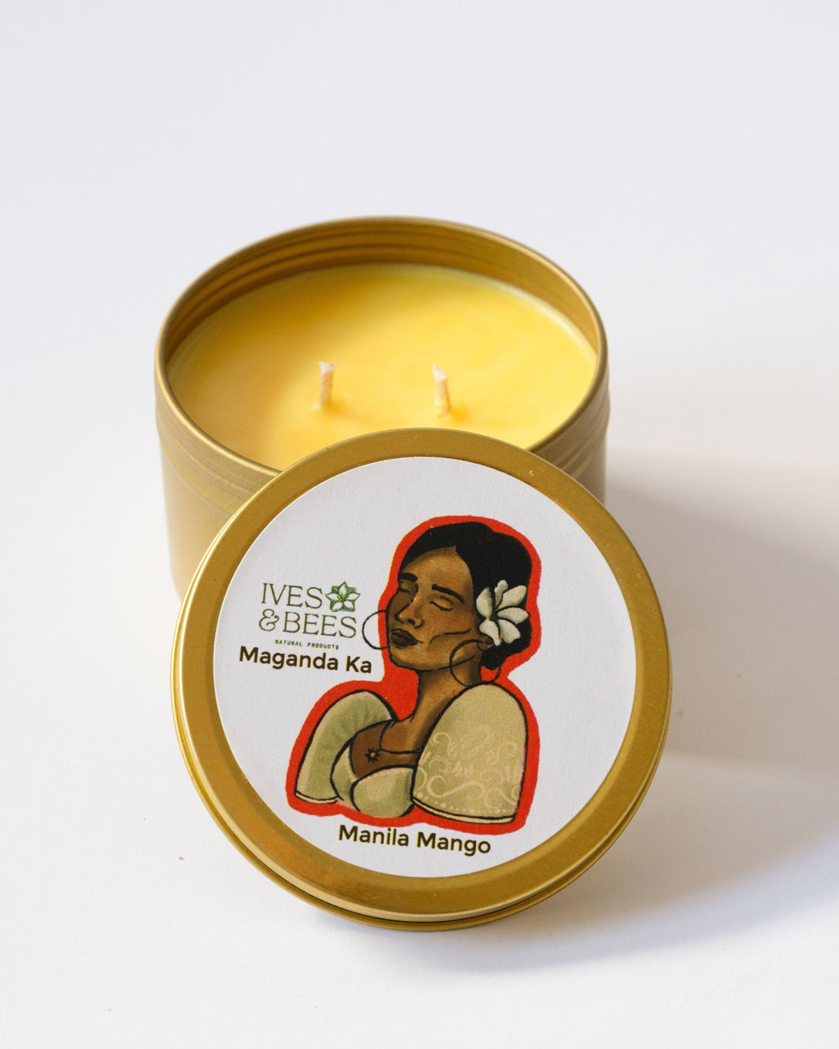 Maganda Ka Candle in a gold tin with a label featuring a woman and the brand 'Ives & Bees'.