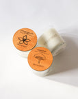 Sampaguita Candle & Narra Candle Duo with round engraved wooden lids, photographed on a clean white background. 